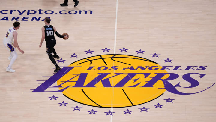 Apr 22, 2023; Los Angeles, California, USA; Memphis Grizzlies guard Luke Kennard (10) dribbles the ball against Los Angeles Lakers guard Austin Reaves (15) at midcourt on the Lakers logo in the first quarter during game three of the 2023 NBA playoffs at Crypto.com Arena. 