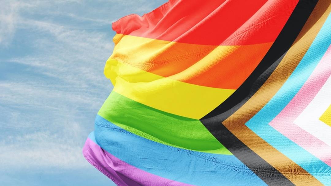 Rainbow Pride flag against blue sky