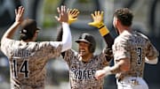 San Diego Padres second baseman Jose Iglesias (7), center, celebrates with Tyler Wade (14), left, and Jackson Merrill (3) after hitting a walk-off fielder’s choice during the ninth inning against the Kansas City Royals at Petco Park on June 22.