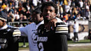 Nov 29, 2024; Boulder, Colorado, USA; Colorado Buffaloes quarterback Shedeur Sanders (2) and head coach Deion Sanders ifollowing the win over the Oklahoma State Cowboys at Folsom Field. Mandatory Credit: Ron Chenoy-Imagn Images