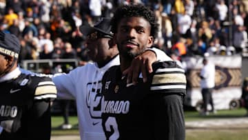 Nov 29, 2024; Boulder, Colorado, USA; Colorado Buffaloes quarterback Shedeur Sanders (2) and head coach Deion Sanders ifollowing the win over the Oklahoma State Cowboys at Folsom Field. Mandatory Credit: Ron Chenoy-Imagn Images