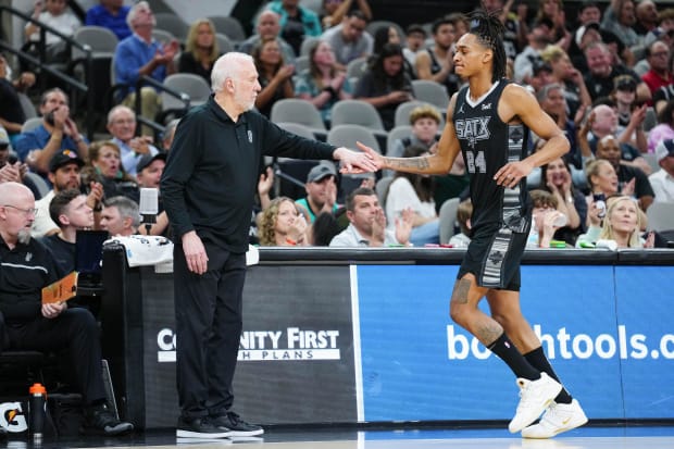 San Antonio Spurs head coach Gregg Popovich shakes hands with San Antonio Spurs guard Devin Vassell (24). 