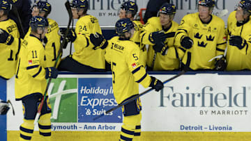 Aug 3, 2024; Plymouth, MI, USA; Sweden's defenseman Wilhelm Hallquisth (5) celebrates a goal against Finland with teammates on the bench during the second period of the 2024 World Junior Summer Showcase at USA Hockey Arena. Mandatory Credit: David Reginek-Imagn Images