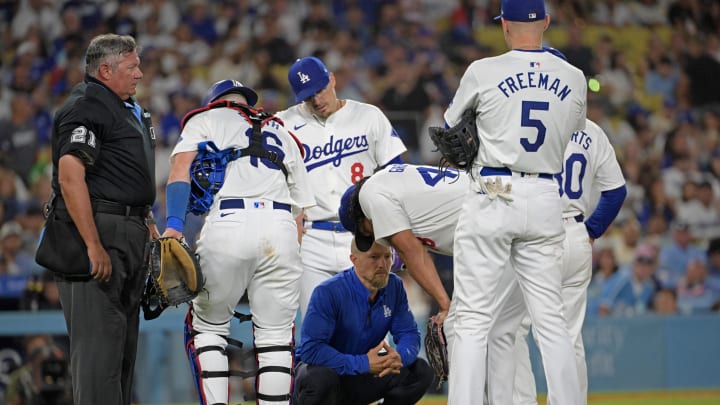 Aug 6, 2024; Los Angeles, California, USA;  Los Angeles Dodgers relief pitcher Brusdar Graterol (41) talks to trainer Thomas Albert in the sixth inning after a hamstring injury against the Philadelphia Phillies at Dodger Stadium. Mandatory Credit: Jayne Kamin-Oncea-USA TODAY Sports