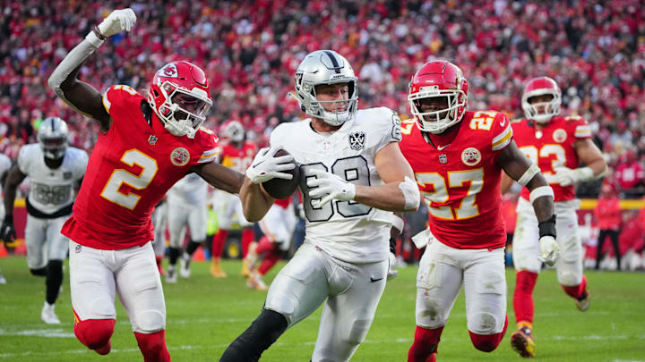 Nov 29, 2024; Kansas City, Missouri, USA; Las Vegas Raiders tight end Brock Bowers (89) scores a touchdown as Kansas City Chiefs cornerback Joshua Williams (2) and safety Chamarri Conner (27) chase during the second half at GEHA Field at Arrowhead Stadium. Mandatory Credit: Denny Medley-Imagn Images