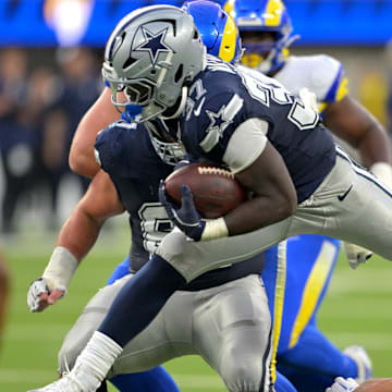 Dallas Cowboys running back Phil Mafah leaps over Los Angeles Rams safety Nate Valcarcel for a first down 