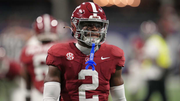 Safety walks during warmups with clear visor and mouthpiece hanging.