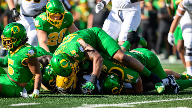  Oregon Ducks defensive lineman Derrick Harmon (55) and linebacker Teitum Tuioti (44) tackle Idaho Vandals running back Elish