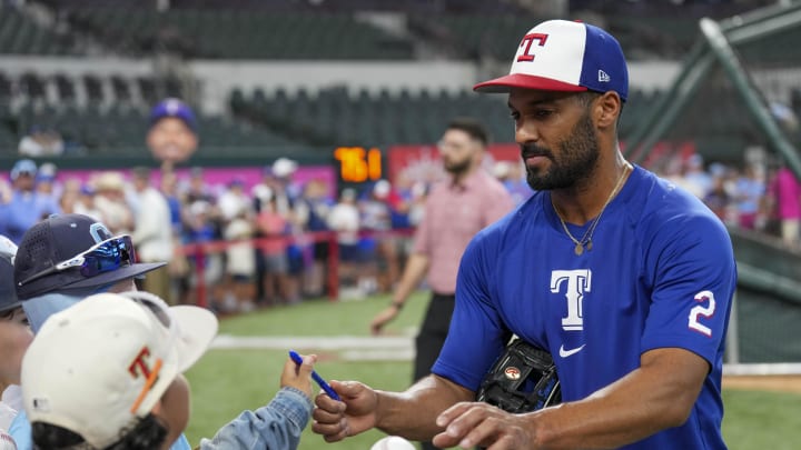 Jun 21, 2024; Arlington, Texas, USA; Texas Rangers second baseman Marcus Semien (2) signs autographs for fans before the game against the Kansas City Royals at Globe Life Field. 