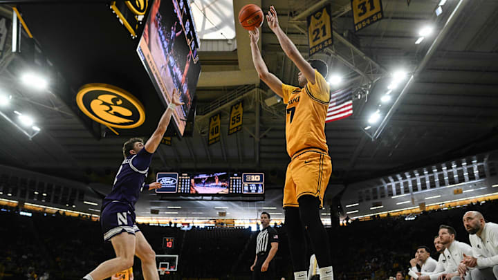 Feb 8, 2026; Iowa City, Iowa, USA; Iowa Hawkeyes forward Alvaro Folgueiras (7) shoots the ball over Northwestern Wildcats forward Nick Martinelli (2) during the second half at Carver-Hawkeye Arena. Mandatory Credit: Jeffrey Becker-Imagn Images