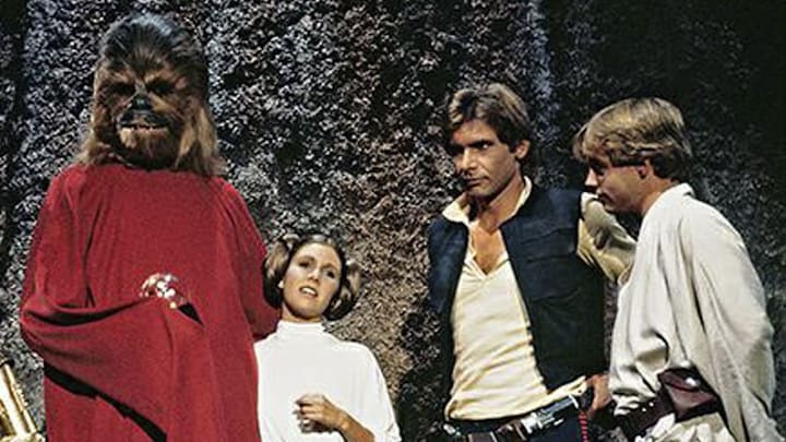 (L to r) R2-D2, Anthony Daniels as C-3PO, Peter Mayhew as Chewbacca, Carrie Fisher as Princess Leia, Harrison Ford as Han Solo, and Mark Hamill as Luke Skywalker in the Star Wars Holiday Special