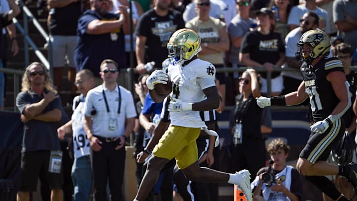 Sep 14, 2024; West Lafayette, Indiana, USA; Notre Dame Fighting Irish running back Jeremiyah Love (4) outruns Purdue Boilermakers defensive back Dillon Thieneman (31) to score a touchdown during the first quarter at Ross-Ade Stadium. Mandatory Credit: Marc Lebryk-Imagn Images