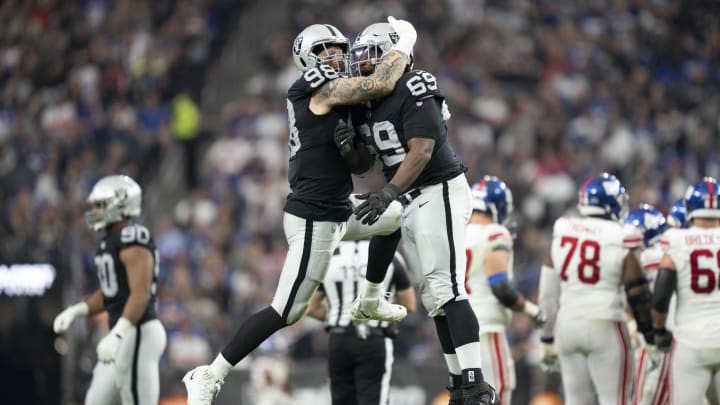 November 5, 2023; Paradise, Nevada, USA; Las Vegas Raiders defensive end Maxx Crosby (98) and defensive tackle Adam Butler (69) celebrate after sacking New York Giants quarterback Tommy DeVito (not pictured) during the third quarter at Allegiant Stadium. Mandatory Credit: Kyle Terada-USA TODAY Sports