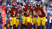 Dec 22, 2024; Landover, Maryland, USA; Washington Commanders quarterback Jayden Daniels (5) celebrates after throwing a touchdown pass during the fourth quarter against the Philadelphia Eagles at Northwest Stadium. Mandatory Credit: Peter Casey-Imagn Images