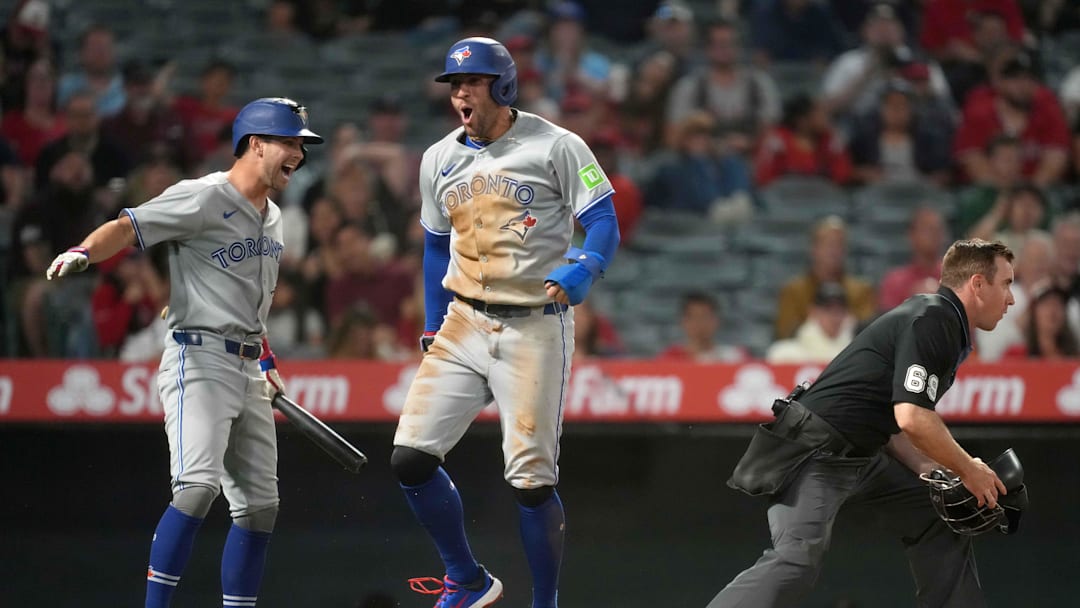 May 8, 2025; Anaheim, California, USA; Toronto Blue Jays designated hitter George Springer (4) celebrates with  second baseman Ernie Clement (22) after scoring on a throwing error in the sixth inning against the Los Angeles Angels at Angel Stadium.