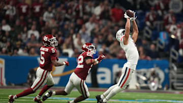 Dec 28, 2023; San Antonio, TX, USA; Arizona Wildcats wide receiver Tetairoa McMillan (4) catches the ball against Oklahoma Sooners defensive back Woodi Washington (5) and defensive back Peyton Bowen (22) in the fist half of the Alamo Bowl at Alamodome. Mandatory Credit: Kirby Lee-Imagn Images