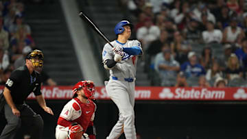 Aug 11, 2025; Anaheim, California, USA; Los Angeles Dodgers designated hitter Shohei Ohtani (17) hits a home run in the eighth inning as Los Angeles Angels catcher Travis d'Arnaud (25) and home plate umpire Dan Iassogna watch at Angel Stadium. Mandatory Credit: Kirby Lee-Imagn Images