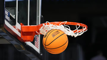 Mar 19, 2025; Wichita, KS, USA; A Wilson official NCAA Evo NXT basketball with the March Madness logo approaches the rim and the net at Intrust Bank Arena. Mandatory Credit: Kirby Lee-Imagn Images