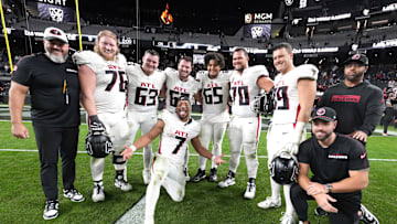 Dec 16, 2024; Paradise, Nevada, USA; Atlanta Falcons running back Bijan Robinson (7) poses with offensive tackle Kaleb McGary (76), guard Chris Lindstrom (63), center Drew Dalman (67), guard Matthew Bergeron (65), offensive tackle Jake Matthews (70) and tight end Charlie Woerner (89) after the game against the Las Vegas Raiders at Allegiant Stadium. Mandatory Credit: Kirby Lee-Imagn Images