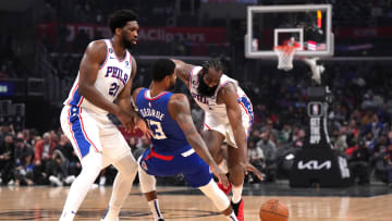 Jan 17, 2023; Los Angeles, California, USA; Philadelphia 76ers guard James Harden (1) collides with LA Clippers guard Paul George (13) as 76ers center Joel Embiid (21) watches in the first half at Crypto.com Arena. Mandatory Credit: Kirby Lee-USA TODAY Sports