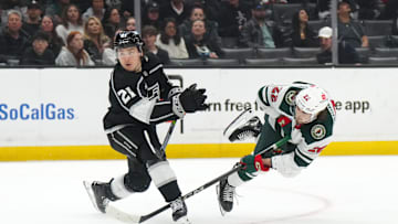 Apr 15, 2024; Los Angeles, California, USA; Minnesota Wild center Marat Khusnutdinov (22) shoots the puck against LA Kings defenseman Jordan Spence (21) in the third period at Crypto.com Arena. Mandatory Credit: Kirby Lee-Imagn Images