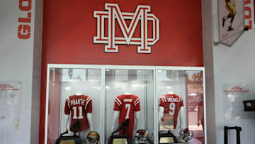 May 24, 2022; Santa Ana, California USA; The high school jerseys and Heisman trophies of John Huarte of Notre Dame (1964), Matt Leinart of Southern California (2004) and Bryce Young of Alabama (2021) on display during the Mater Dei High Heisman Homecoming ceremony at the Meruelo Athletic Center.