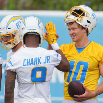 Jun 13, 2024; Costa Mesa, CA, USA; Los Angeles Chargers quarterback Justin Herbert (10) interacts with wide receivers Quentin Johnston (1), Simi Fehoko (87) and D.J. Clark (9) during minicamp at the Hoag Performance Center.  Mandatory Credit: Kirby Lee-USA TODAY Sports