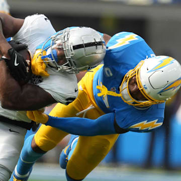 Sep 8, 2024; Inglewood, California, USA; Las Vegas Raiders running back Zamir White (left) is tackled by Los Angeles Chargers safety Derwin James Jr (3) in the second half at SoFi Stadium. Mandatory Credit: Kirby Lee-Imagn Images