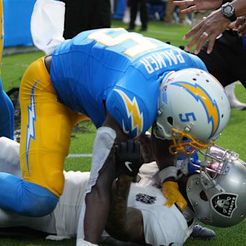 Sep 8, 2024; Inglewood, California, USA; Los Angeles Chargers wide receiver Joshua Palmer (5) and Las Vegas Raiders safety Marcus Epps (1) fight n the second half at SoFi Stadium. Mandatory Credit: Kirby Lee-Imagn Images