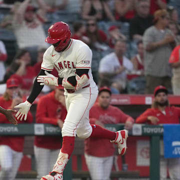 Los Angeles Angels right fielder Jo Adell (7) is congratulated by third base coach Eric Young Sr. (85)  after hitting a home run in the third inning against the Seattle Mariners at Angel Stadium on Aug 31.