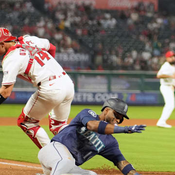 Seattle Mariners center fielder Victor Robles (10) slides into home plate  to beat  a throw to Los Angeles Angels catcher Logan O'Hoppe (14) to score in the fourth inning at Angel Stadium on Aug 31.