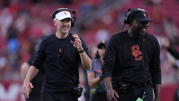 Southern California Trojans head coach Lincoln Riley (leff) and wide receivers coach Dennis Simmons react against the Nevada 