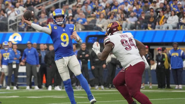 Los Angeles Rams quarterback Matthew Stafford (9) throws the ball under pressure from Washington Commanders defensive tackle 