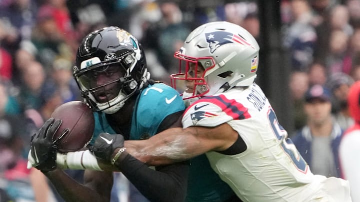 Oct 20, 2024; London, United Kingdom; Jacksonville Jaguars wide receiver Brian Thomas Jr. (7) catches a 58-yard pass against New England Patriots cornerback Christian Gonzalez (0) in the first half of an NFL International Series game at Wembley Stadium. Mandatory Credit: Kirby Lee-Imagn Images