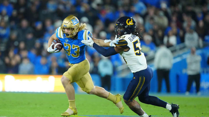 Nov 25, 2023; Pasadena, California, USA; UCLA Bruins running back Carson Steele (33) carries the ball against California Golden Bears linebacker Kaleb Elarms-Orr (53) in the first half at Rose Bowl. Mandatory Credit: Kirby Lee-USA TODAY Sports