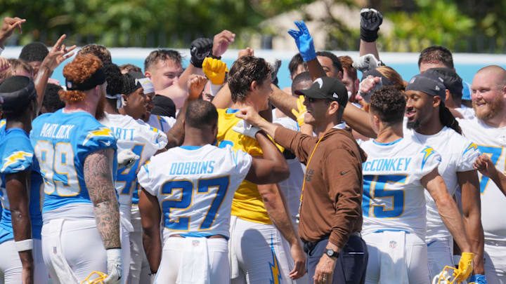 Jun 13, 2024; Costa Mesa, CA, USA; Los Angeles Chargers coach Jim Harbaugh joins hands in a huddle with tight end Donald Parham Jr. (89), running back J.K. Dobbins (27), quarterback Justin Herbert (10) and receiver Ladd McConkey (15) during minicamp at the Hoag Performance Center. Mandatory Credit: Kirby Lee-Imagn Images