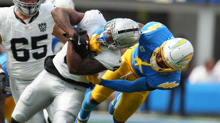 Sep 8, 2024; Inglewood, California, USA; Las Vegas Raiders running back Zamir White (left) is tackled by Los Angeles Chargers safety Derwin James Jr (3) in the second half at SoFi Stadium. Mandatory Credit: Kirby Lee-Imagn Images