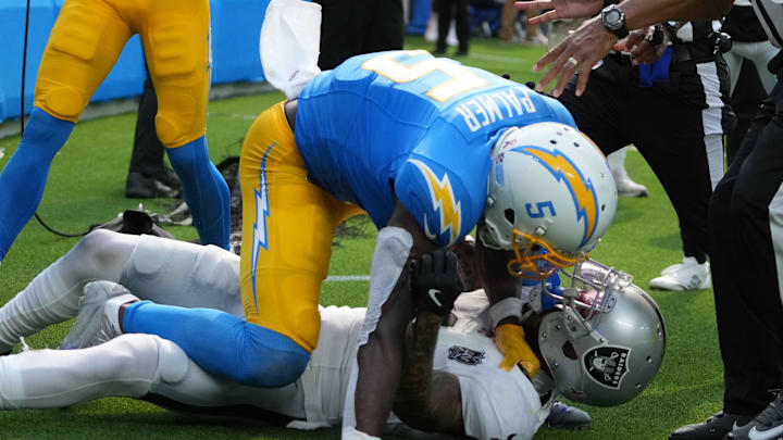 Sep 8, 2024; Inglewood, California, USA; Los Angeles Chargers wide receiver Joshua Palmer (5) and Las Vegas Raiders safety Marcus Epps (1) fight n the second half at SoFi Stadium. Mandatory Credit: Kirby Lee-Imagn Images