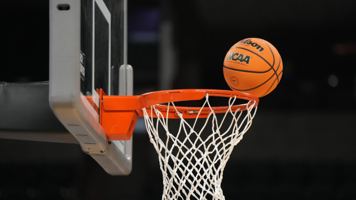 Mar 21, 2024; Spokane, WA, USA; A Wilson official  Evo NXT basketball with March Madness logo approaches the rim and net at Spokane Veterans Memorial Arena. Mandatory Credit: Kirby Lee-USA TODAY Sports