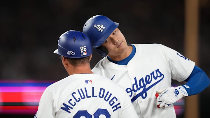Aug 21, 2024; Los Angeles, California, USA; Los Angeles Dodgers designated hitter Shohei Ohtani (17) bumps helmets with first base coach Clayton McCullough (86) after hitting a single in the fifth inning against the Seattle Mariners at Dodger Stadium. Mandatory Credit: Kirby Lee-Imagn Images