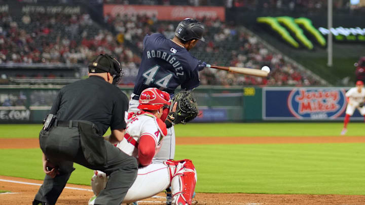 Seattle Mariners center fielder Julio Rodriguez (44) hits a two-RBI single in the fourth inning as Los Angeles Angels catcher Logan O'Hoppe (14) and  home plate umpire Jansen Visconti watch at Angel Stadium on Aug. 31.