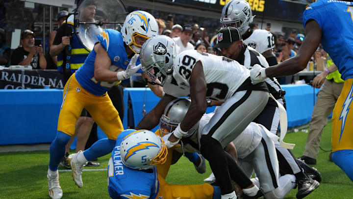 Sep 8, 2024; Inglewood, California, USA; Los Angeles Chargers wide receivers Joshua Palmer (5), Ladd McConkey (15) and Quentin Johnston (1) and Las Vegas Raiders safety Marcus Epps (1) and wide receiver Jaylen Johnson (39) fight as back judge Terrence Miles (111) intervenes in the second half at SoFi Stadium. Mandatory Credit: Kirby Lee-Imagn Images