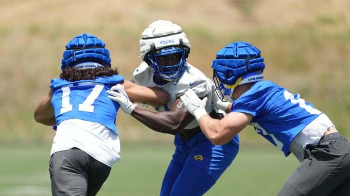 May 21, 2024, Thousand Oaks, California, USA; Los Angeles Rams linebacker Byron Young (0) is defended by wide receiver Puka Nacua (17) and tight end Colby Parkinson (86) during organized team activities at Cal Lutheran University. Mandatory Credit: Kirby Lee-USA TODAY Sports