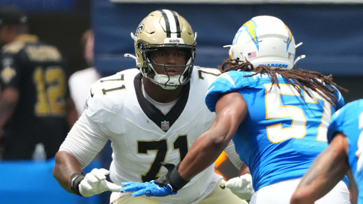 Aug 10, 2025; Inglewood, California, USA; New Orleans Saints offensive tackle Kelvin Banks Jr. (71) defends against Los Angeles Chargers linebacker Tre'Mon Morris-Brash (57) in the first half at SoFi Stadium. Mandatory Credit: Kirby Lee-Imagn Images