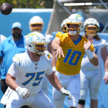 May 29, 2024; Costa Mesa, CA, USA; Los Angeles Chargers quarterback Justin Herbert (10) throws the ball as center Bradley Bozeman (75) and guard Zion Johnson (77) defend during organized team activities at Hoag Performance Center. Mandatory Credit: Kirby Lee-USA TODAY Sports