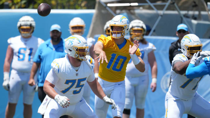 May 29, 2024; Costa Mesa, CA, USA; Los Angeles Chargers quarterback Justin Herbert (10) throws the ball as center Bradley Bozeman (75) and guard Zion Johnson (77) defend during organized team activities at Hoag Performance Center. Mandatory Credit: Kirby Lee-USA TODAY Sports