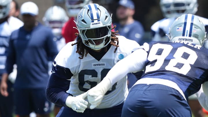 Dallas Cowboys tackle Tyler Guyton defends against defensive end Payton Turner during training camp 