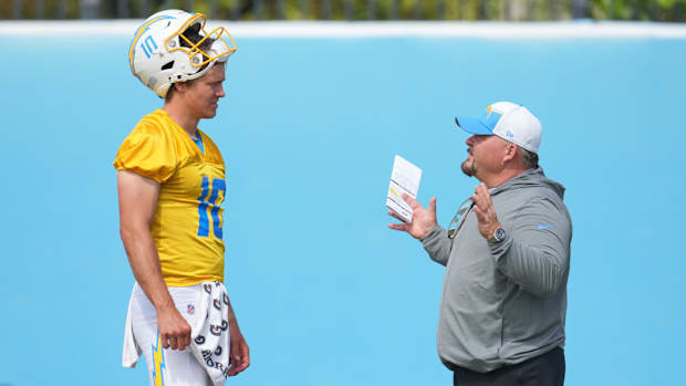 Justin Herbert speaks to Los Angeles Chargers OC Greg Roman at practice.
