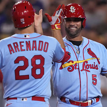 Sep 24, 2022; Los Angeles, California, USA;  St. Louis Cardinals third baseman Nolan Arenado (28) celebrates with designated hitter Albert Pujols (5) after hitting a two run home run against the Los Angeles Dodgers in the sixth inning at Dodger Stadium. Mandatory Credit: Kirby Lee-Imagn Images