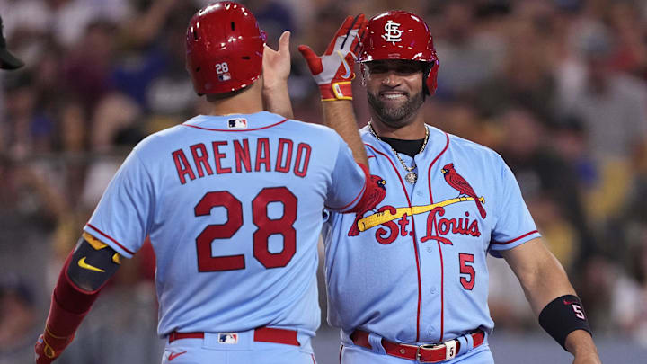 Sep 24, 2022; Los Angeles, California, USA;  St. Louis Cardinals third baseman Nolan Arenado (28) celebrates with designated hitter Albert Pujols (5) after hitting a two run home run against the Los Angeles Dodgers in the sixth inning at Dodger Stadium. Mandatory Credit: Kirby Lee-Imagn Images